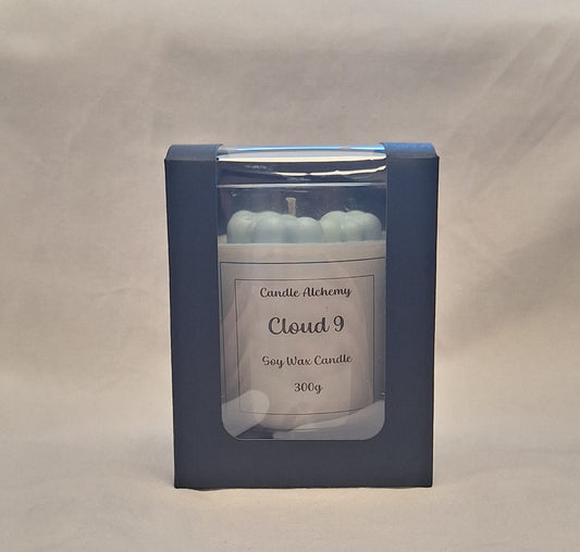 Handmade Cloud 9 soy wax candle in luxury black packaging with visible blue cloud wax decorations on top.
